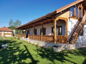 Traditional Romanian house, wood, large green courtyard.