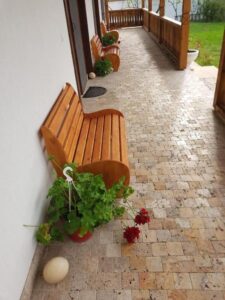 Wooden benches on the veranda with potted flowers.