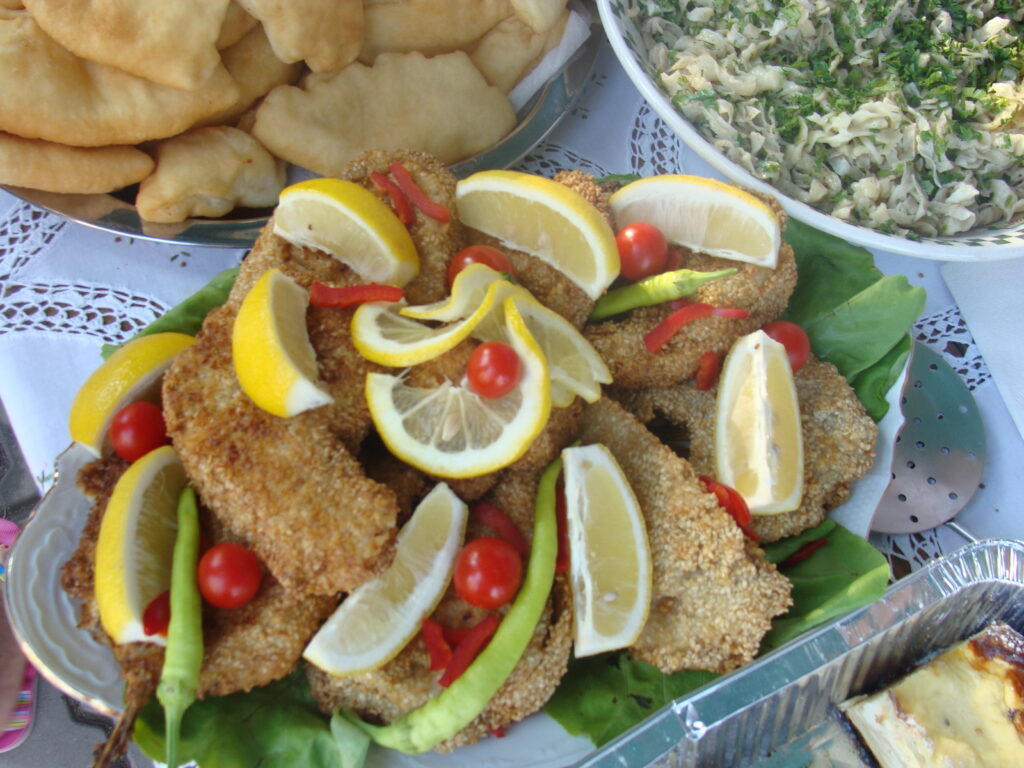 Buffet with fried fish and fresh vegetables.