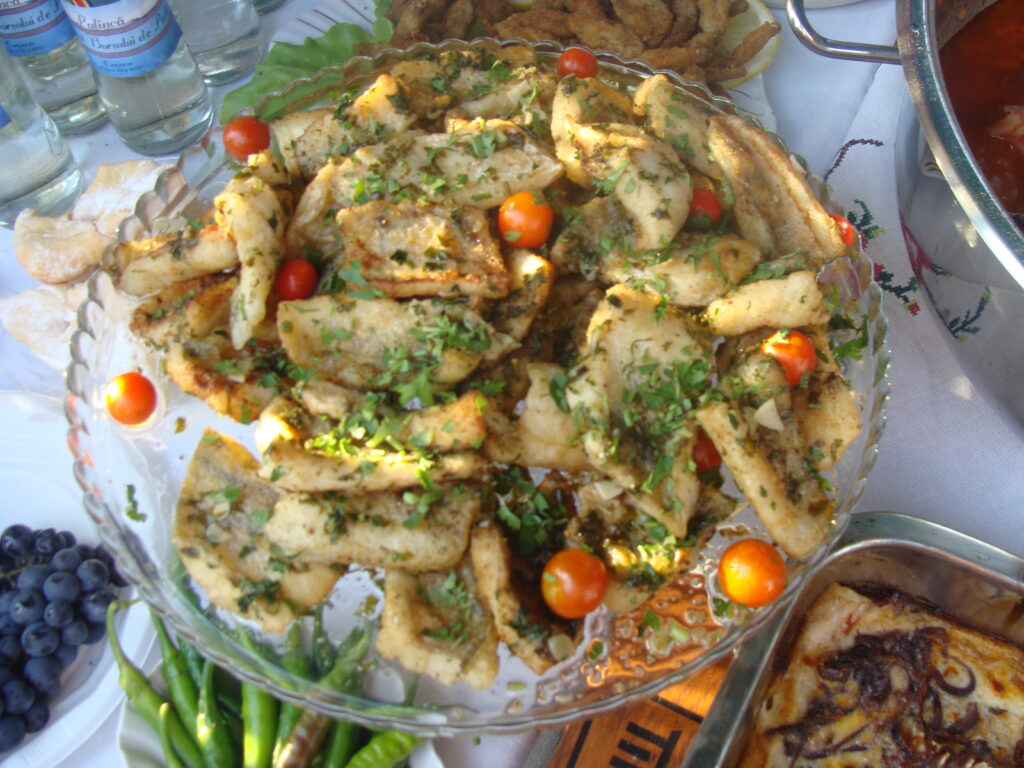 Pan-fried fish platter with greens and cherry tomatoes.