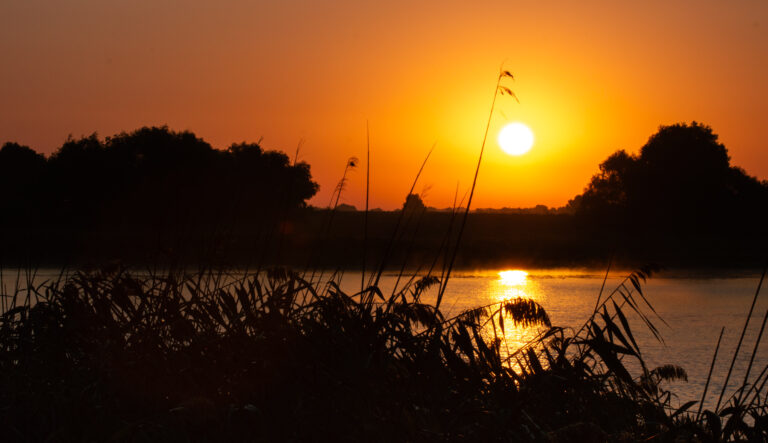 Sunset over still water