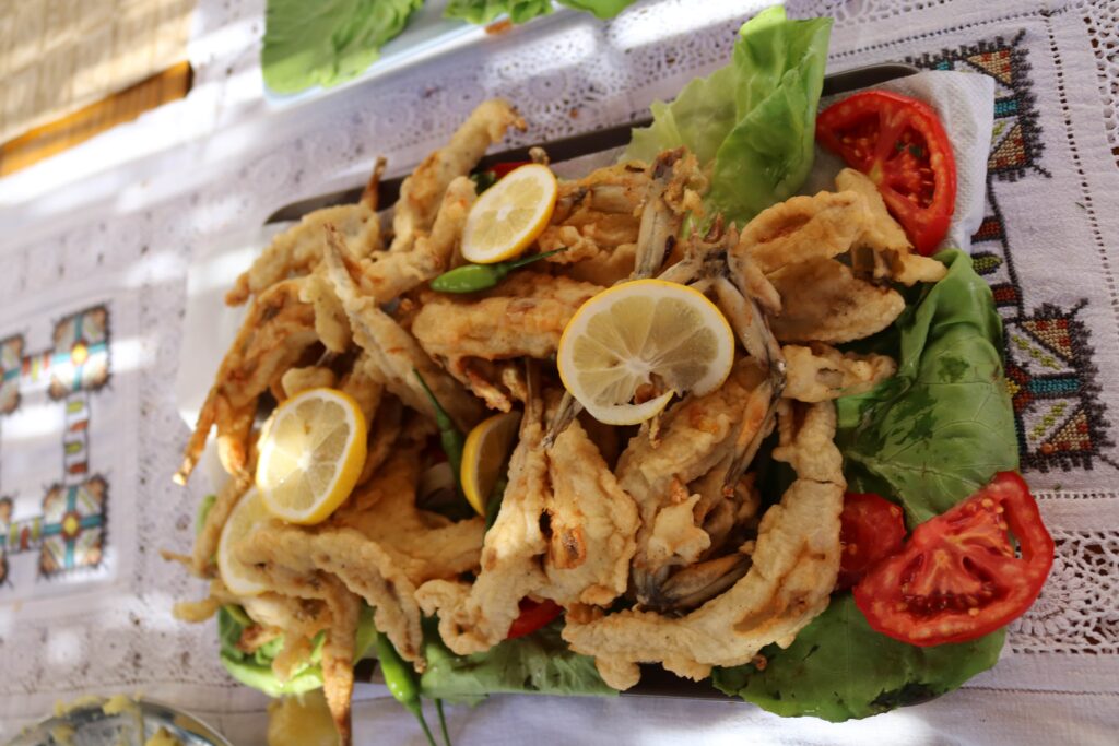 Fried frog legs served with lemon and salad
